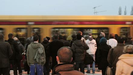 Fahrgäste warten an einem S-Bahn-Gleis.
