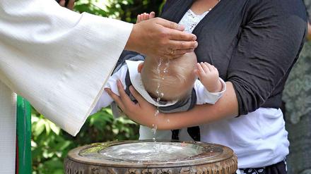 Ein Kind wird getauft.