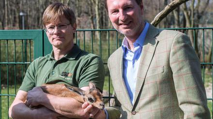 Ein Pfleger und Zoo- und Tierparkdirektor Andreas Knieriem mit dem Giraffengazellenbaby Tayo.