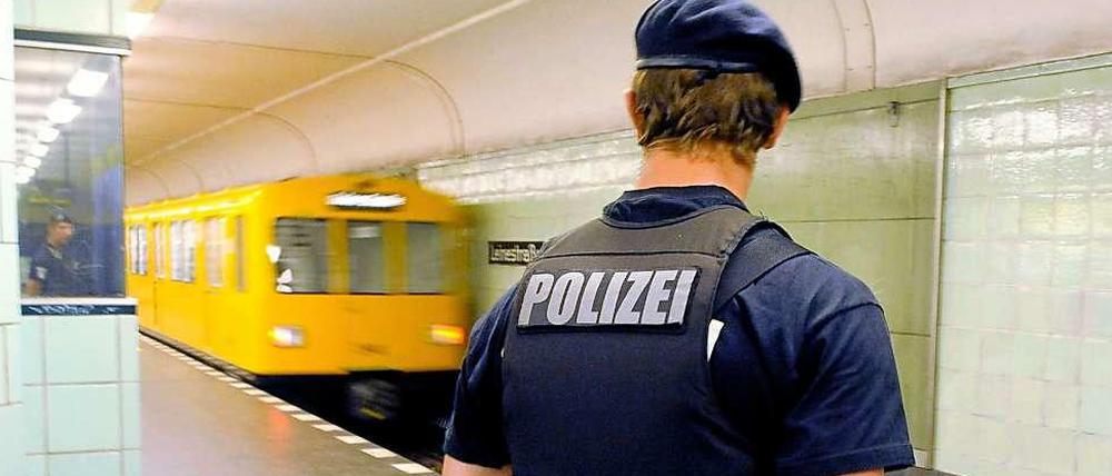 Ein Polizist steht vor einem Bahngleis.
