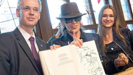 Udo präsentiert seinen skizzierten Eintrag ins Goldene Buch. Neben ihm Bezirksbürgermeister Matthias Köhne und die Musicaldarstellerin Josephin Busch.