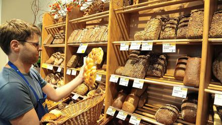 Reichhaltiges Sortiment. Naturkostfachverkäufer Cedric Quentin füllt die Regale der trotz Insolvenz weiter geführten Bäckerei in der Ufa-Fabrik. 