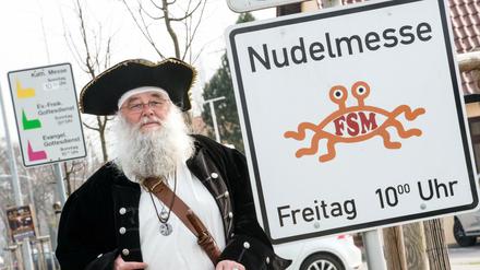  Rüdiger Weida von der "Kirche der fliegenden Spaghettimonster" neben seinem Schild "Nudelmesse" in Templin (Brandenburg).