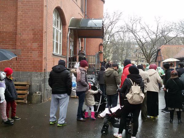 Menschen stehen auf dem Gelände des Lageso an der Turmstraße in Moabit vor Haus D für warme Kleidung, Spielsachen, Hygieneartikel an. 