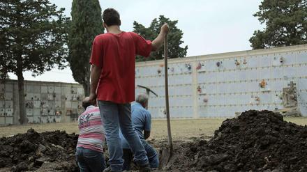 Aktivisten heben ein Grab auf Sizilien aus.