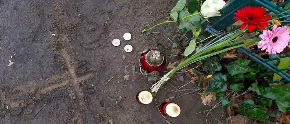 Blumen, Tee- und Grablichter neben einem in den Boden geritztem Kreuz in Eichwalde (Brandenburg). Am Vortag war an dieser Stelle ein 14-jähriges Mädchen erstochen worden.