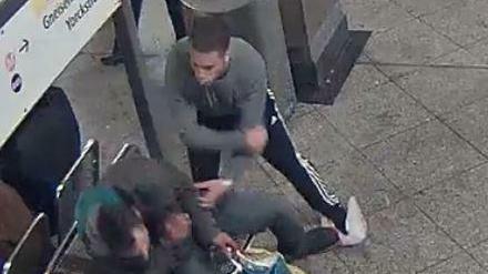 Einer der Angreifer schlägt am U-Bahnhof Mehringdamm auf einen Obdachlosen ein. 