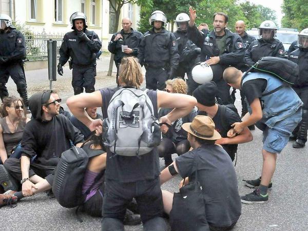 Die Polizei löst eine erste kleine Sitzblockade von Gegendemonstranten in Neuruppin auf.