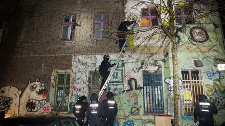 Polizisten steigen über Leitern in das Haus in der Rigaer Straße 94 ein.