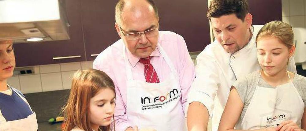 Alle mal mitmachen. Bundesminister Christian Schmidt und Fernsehkoch Tim Mälzer kochen mit Schülerinnen und Schülern der Schule Eins aus Pankow. 