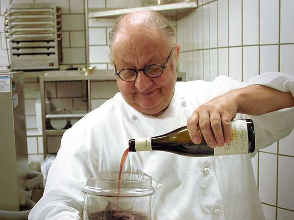 Vincent Klink mit seinem Essigglas, in das verschiedene Weine fließen