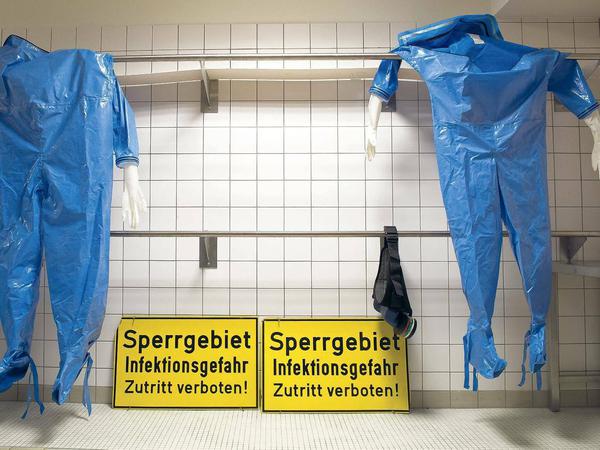 Blaumänner. Schutzanzüge hängen im Ankleideraum einer Quarantänestation in der Charité. Die Station ist darauf vorbereitet, Patienten mit Tropenkrankheiten wie Ebola aufzunehmen. 