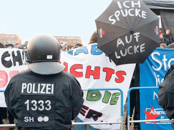 Umstritten. Während der Vorsitzende Bernd Lucke im Saal seinen Triumph feiert, hält die Polizei vor der Tür einige tausend Demonstranten in Schach.