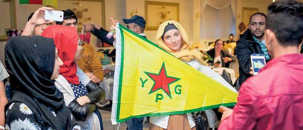 Waffenschwester. Auf einer Feier in Wedding schwenkt eine Kurdin die Fahne der Volksverteidigungseinheiten „YPG“, die in Syrien gegen Islamisten kämpfen.