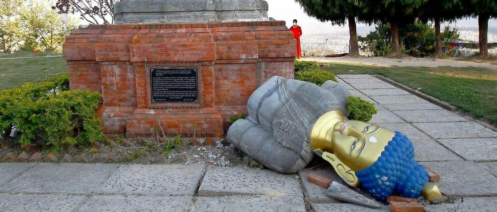 Eine zerbrochene Buddhafigur in einer Tempelanlage.