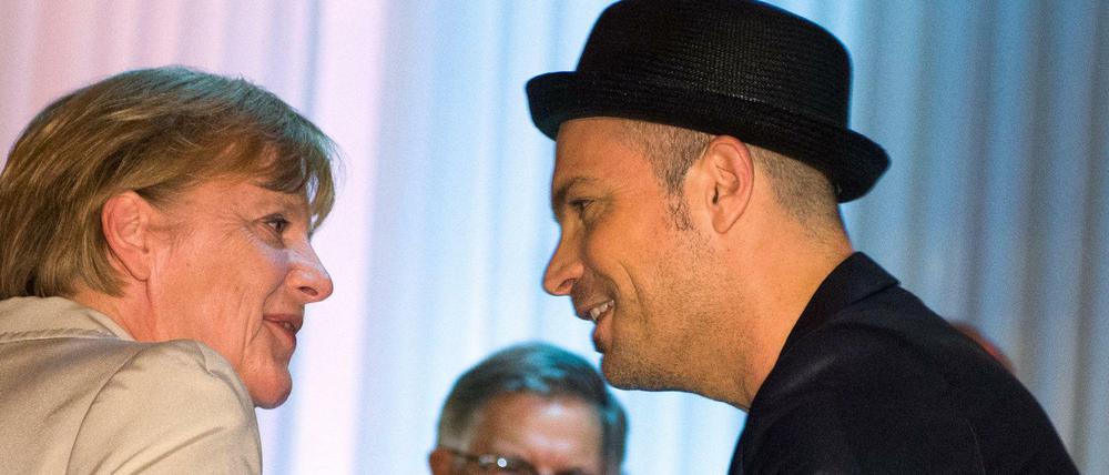 Sänger grüßt Kanzlerin: Roger Cicero und Angela Merkel beim VPRT-Sommerfest