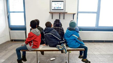 Kinder von Asylbewerbern sehen in der Landeserstaufnahmestelle in Baden-Württemberg fern.
