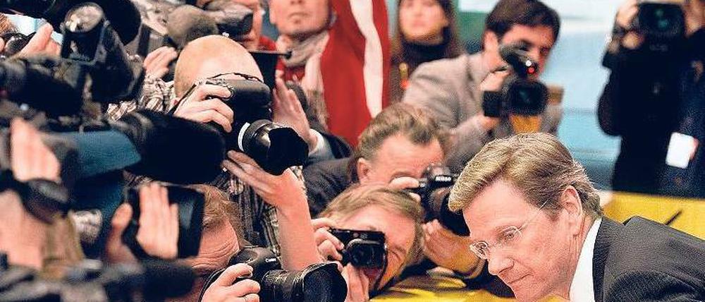 Alle warten schon. Guido Westerwelle, Bundesaußenminister und FDP-Chef, nimmt in der Bundespressekonferenz Platz. Gleich wird das Frage-und-Antwort-Spiel beginnen. 