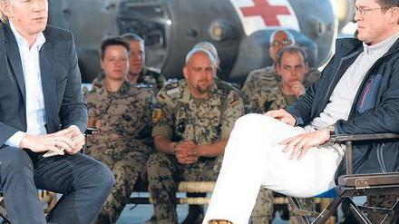 Truppen-Talk. Johannes B. Kerner (vorne links) verlegte seine Talksendung am 13. Dezember 2010 nach Masar-i-Scharif in Afghanistan, wo er mit Verteidigungsminister zu Guttenberg sprach. Foto: dpa