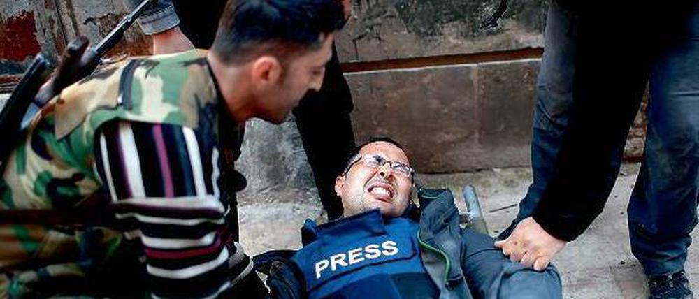 Angeschossen. Der Kameramann der Nachrichtenagentur Reuters, Ayman al Sahili, liegt mit einer Kugel im Bein in Aleppo verletzt am Boden. Foto: Reuters