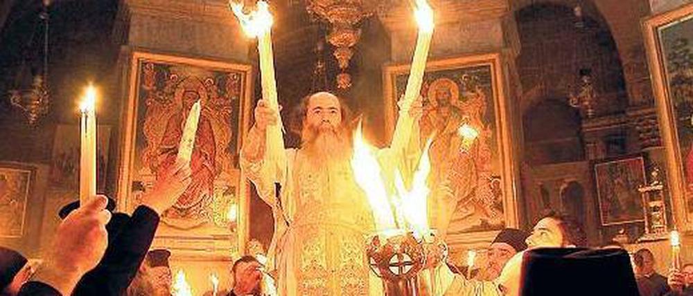Griechisch-orthodoxe Mönche feiern die Auferstehung Christi mit dem Wunder des heiligen Feuers. 