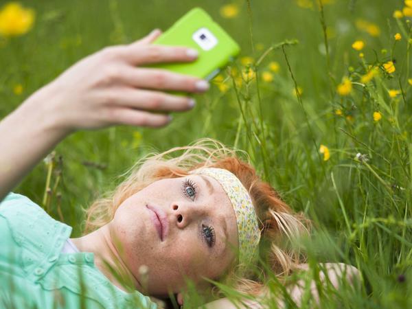 Mädchen mit Smartphone im Gras