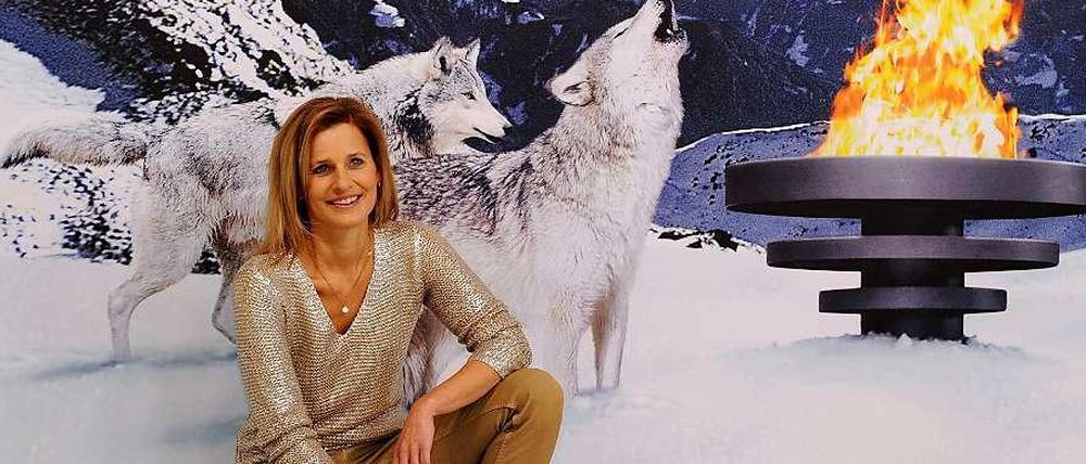 Kitsch mit Katrin Müller-Hohenstein. Die ZDF-Moderatorin posiert vor einem Werbeplakat für die olympischen Winterspiele in Sotschi.