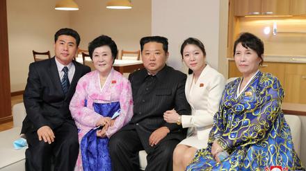Händchen halten mit oberstem Führer. Kim Jong-un (Mitte) posiert mit Chefsprecherin Ri Chun-hee (zweite von links) and ihrer Familie in der Wohnung, die der Diktator Ri geschenkt hat. 