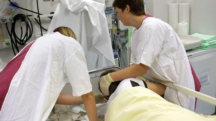 Zwei Krankenschwestern kümmern sich in der Notaufnahme um einen stark betrunkenen Jugendlichen.