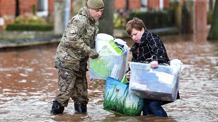 Ein Soldat hilft einer Frau in Carlisle. 