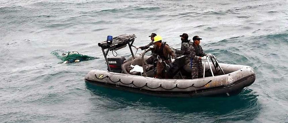 Indonesisches Militär wirft ein Netz aus, um Opfer und Wrackteile zu finden.