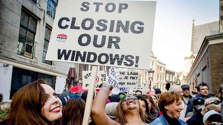 "Stop Closing Our Windows!", steht auf diesem Schild einer Demonstrantin. Gemeinsam mit mehr als hundert anderen Menschen demonstriert sie gegen die Schließung von Rotlicht-Fenstern in Amsterdam. 