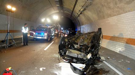 Das Wrack eines zerstörten Autos liegt am Mittwoch nach einem Unfall im Hörnchenbergtunnel auf der Autobahn A62 bei Landstuhl (Rheinland-Pfalz) auf dem Dach. Eine 24-Jährige PKW-Fahrerin war mit dem Wagen an der rechten Tunnelwand die Röhre hinauf, an der Decke entlang und bis zur gegenüberliegenden Wand gefahren, bis der Wagen auf dem Dach nach mehreren Metern zum Stillstand kam. Die Frau kam mit schweren Verletzungen in ein Krankenhaus.