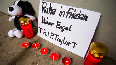 Ein Schild mit der Aufschrift "Ruhe infrieden kleiner Engel. R.I.P. Tayler", Kerzen und ein Plüschtier stehen in Hamburg.