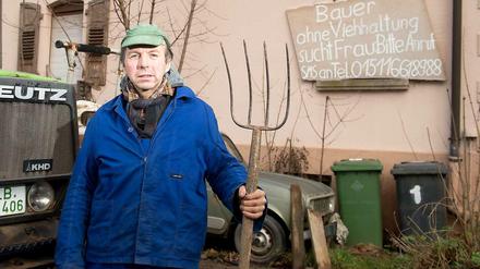 Der Bauer Roland Geiger vor seinem Brautschau-Plakat. 