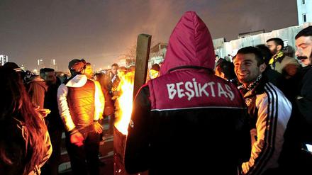 Fußballfans von Besiktas Istanbul wärmen sich während einer Protestversammlung gegen den Prozess gegen ihre Kameraden an einem Feuer.