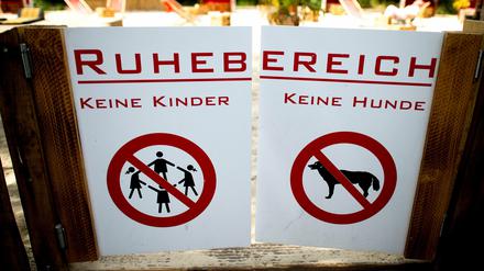 Verbotsschilder für Kinder und Hunde sind am Donnerstag in Düsseldorf an einer Tür zum Ruhebereich eines Biergartens angebracht. Mit einer kinderfreien Zone hat sich ein Biergarten-Betreiber Ärger vor allem mit Müttern eingehandelt. 