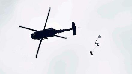 Ein Fallschirmspringen springt aus einem Hubschrauber des Typs "Black Hawk". 