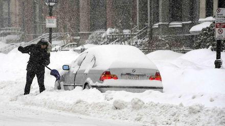 Ein Mann in Boston befreit sein Auto vom Schnee.