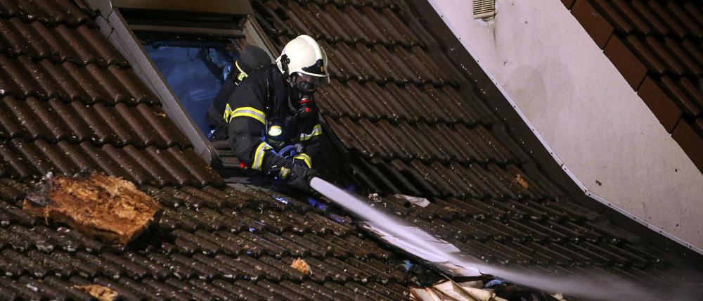 Ein Feuerwehrmann löscht am Mittwoch den Brand in einem Haus in Langen (Hessen). Während einer Feier von sechs Jugendlichen ist in dem Einfamilienhaus ein Feuer ausgebrochen. Die Eltern seien laut Polizei zum Zeitpunkt des Brandes nicht zu Hause gewesen.
