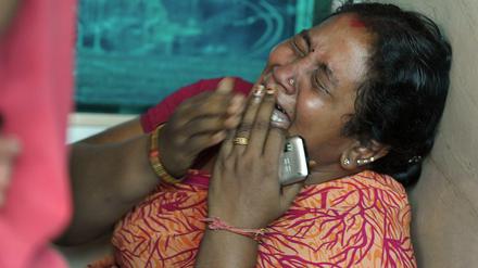 Eine Angehörige weint um ein Opfer des Busunglücks in Südindien. Mindestens 44 Menschen waren dabei ums Leben gekommen.
