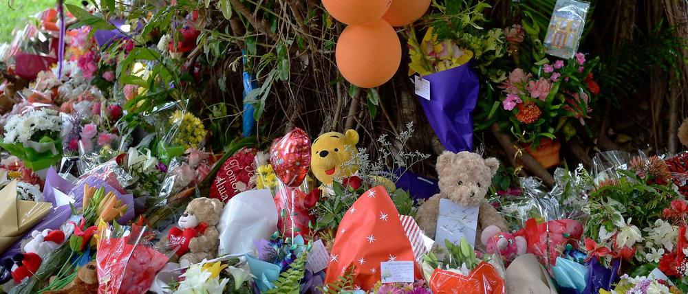 Bewohner von Cairns in Australien haben Blumen und Kuscheltiere in der Nähe des Hauses abgelegt, wo acht tote Kinder gefunden worden waren.