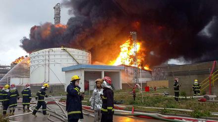 Feuerwehrleute am Dienstag vor der in Brand geratenen Chemiefabrik in Zhangzhou, China. 
