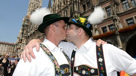 Christian (l) und Georg küssen sich beim Christopher Street Day am vor dem Rathaus in München.
