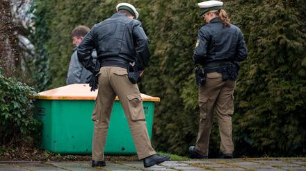 Zwei Polizisten begutachten am Montag in Bayreuth nach einer Schießerei mit drei Toten und einem Schwerverletzten den Bereich eines Tatortes.