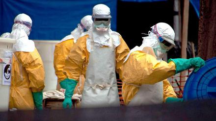 Mitarbeiter in Schutzanzügen reinigen den Patientenbereich in einem Ebola-Behandlungszentrum.