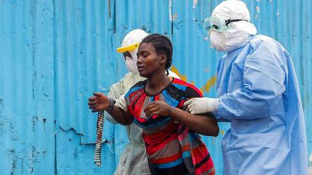 Eine an Ebola erkrankte Frau in Liberia wird von Klinikmitarbeitern in Monrovia betreut.