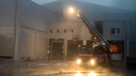 Feuerwehrmänner löschen am Montag in Bogen (Bayern) eine Halle. 