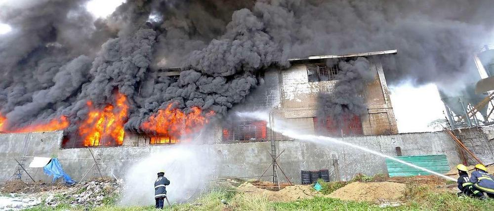Feuerwehrleute auf den Philippinen versuchen am Mittwoch, das Feuer in einer Schuhfabrik zu löschen. 