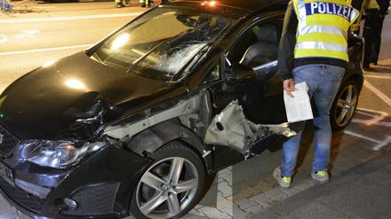 Ein Polizist untersucht das Auto des Rasers an der Unfallstelle in Mönchengladbach. 